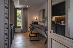 14. Room Deluxe King Room workspace with modern desk coffee amenities and large window view - PASSA HOTEL BANGKOK