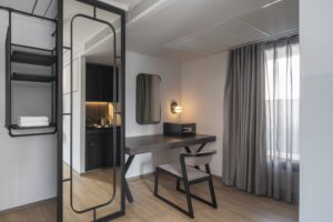 19. Room Modern Silom Bangkok hotel room workspace with large mirror safe and tea station at Passa Hotel Bangkok - PASSA HOTEL BANGKOK