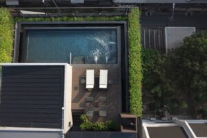 30. Facilities Aerial view of rooftop swimming pool at Passa Hotel Bangkok with sun loungers and lush greenery - PASSA HOTEL BANGKOK
